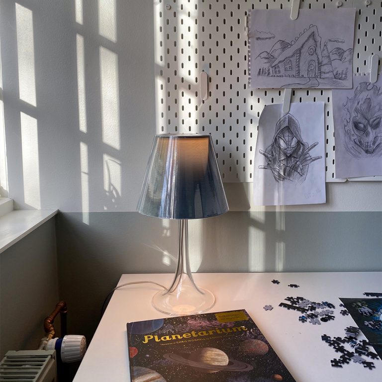 Skrivebord med opslagsvæg og lampe og igangværende puslespil