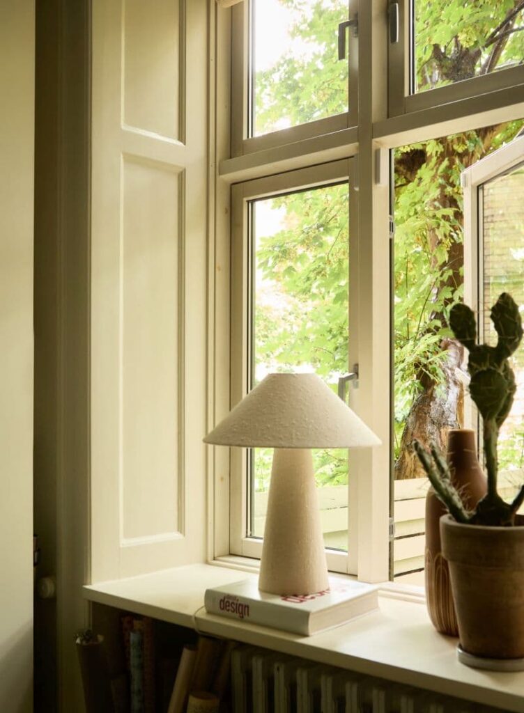 Indretning af vindueskarm med lampe og kaktus