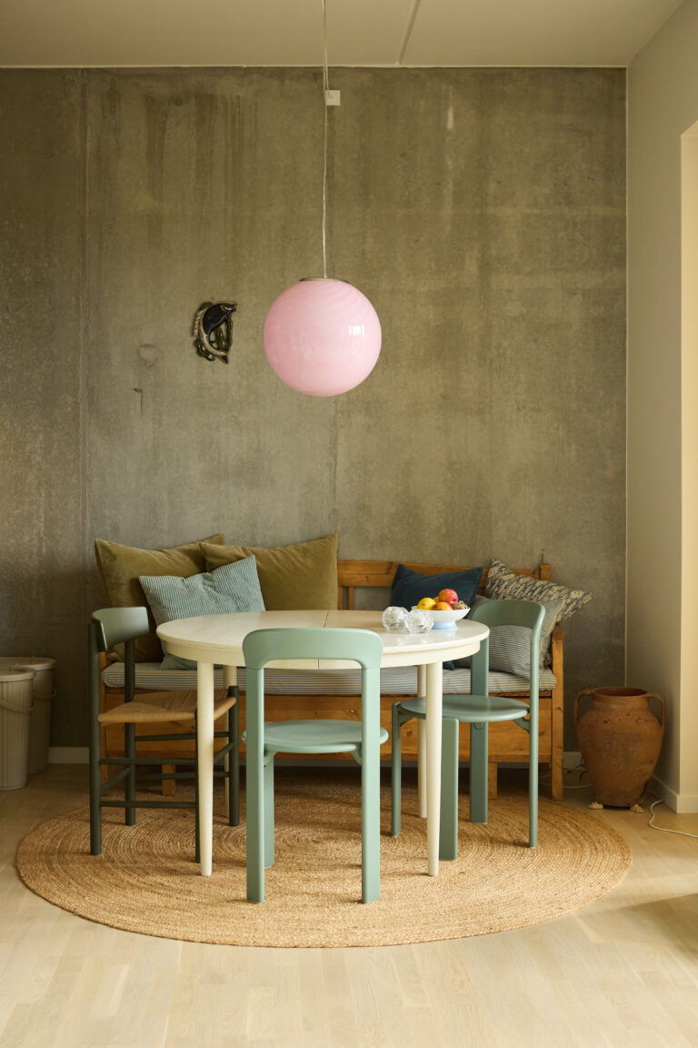 spisestue med rundt spisebord med stole i blå nuancer samt muranolampe i pink